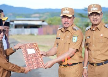 Bupati Kerinci Monadi menyerahkan penghargaan kepada salah satu perwakilan koperasi berprestasi pada upacara peringatan Hari Koperasi Nasional ke-78 di halaman Kantor Bupati Kerinci, Senin (21/7/2025). (Dok. Yola)