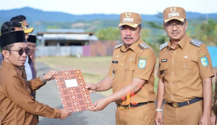 Bupati Kerinci Monadi menyerahkan penghargaan kepada salah satu perwakilan koperasi berprestasi pada upacara peringatan Hari Koperasi Nasional ke-78 di halaman Kantor Bupati Kerinci, Senin (21/7/2025). (Dok. Yola)