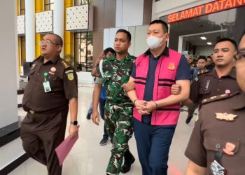 Tersangka BK, Komisaris Utama PT PAL, digiring petugas Kejati Jambi usai ditetapkan sebagai tersangka dalam kasus dugaan korupsi fasilitas kredit investasi dan modal kerja PT Bank BNI senilai Rp105 miliar, Senin (22/7/2025). (Foto: Stepanus)