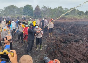 Kapolda Jambi Irjen Pol Krisno H Siregar dan Dansat Brimob Polda Jambi Kombes Pol Muhammad Faishal Aris memantau sekaligus ikut memadamkan kebakaran lahan di Desa Gambut Jaya, Kecamatan Sungai Gelam, Muaro Jambi, Sabtu (26/7/2025). (Dok. Nahar)