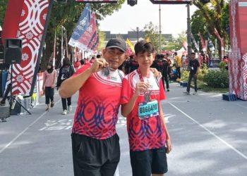 AKBP Dr. Dadang Djoko Karyanto berfoto bersama salah satu pelajar peserta Presisi Merdeka Run 2025 kategori 5K di Lapangan Kantor Gubernur Jambi, Minggu (3/8/2025) (Dok. Nahar)