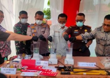 Petugas dari Kejaksaan Negeri Tanjung Jabung Timur bersama unsur Forkopimda memusnahkan barang bukti tindak pidana, termasuk narkotika, dengan cara diblender di halaman Kejari Tanjab Timur, Kamis (21/8/2025). (Dok Daus)