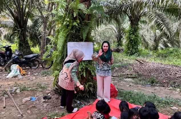 Bunda PAUD Sarolangun, Hj. Risya Fitria, bersama relawan memberikan pembelajaran bagi anak-anak Suku Anak Dalam (SAD) di Punti Kayu 1, Desa Bukit Suban, Kecamatan Air Hitam, Kabupaten Sarolangun, Senin (25/8/2025). (Dok. Stepanus)