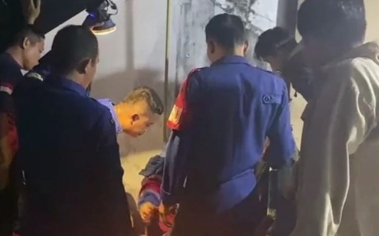 Petugas Damkar Kota Jambi mengevakuasi seekor anak kucing yang terjebak di saluran sempit rumah warga di Pematang Sulur, Telanaipura, Rabu (27/8/2025). (Dok. Daus)