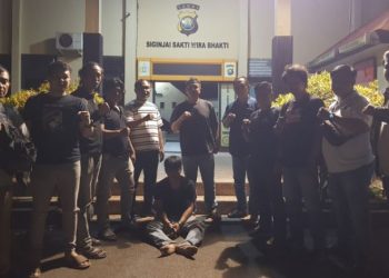 Petugas gabungan dari Polsek Kota Baru dan Polresta Jambi berhasil menangkap tersangka pencurian sepeda motor di kawasan Paal Lima, Kota Jambi. Tersangka duduk di depan Mapolsek Kota Baru usai ditangkap, Jumat malam (1/8/2025). (Dok. Stepanus)
