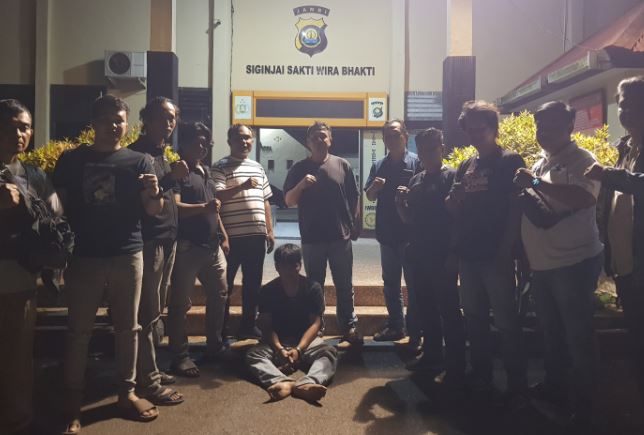 Petugas gabungan dari Polsek Kota Baru dan Polresta Jambi berhasil menangkap tersangka pencurian sepeda motor di kawasan Paal Lima, Kota Jambi. Tersangka duduk di depan Mapolsek Kota Baru usai ditangkap, Jumat malam (1/8/2025). (Dok. Stepanus)