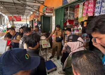 Petugas gabungan dari Satgas Pangan Provinsi Jambi dan Ditreskrimsus Polda Jambi memeriksa alat timbang dan barang dagangan di salah satu toko grosir di Pasar Angso Duo, Jambi, saat inspeksi mendadak terkait dugaan peredaran beras oplosan, Rabu (17/7/2025). (Dok. Daus)