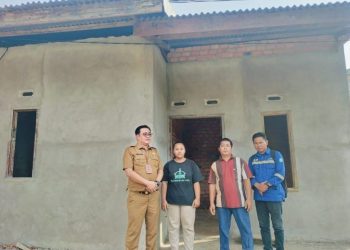 Ariesto Harun Wijaya, Kabid Perumahan dan Permukiman Dinas PUPR Provinsi Jambi, bersama warga penerima bantuan saat meninjau progres program bedah rumah di Kota Jambi, Selasa(5/8/2025). (Dok. Stepanus)