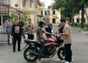 Kapolresta Jambi Kombes Pol. Boy Sutan Binanga Siregar membagikan dan memasangkan langsung Bendera Merah Putih pada kendaraan pengendara di depan Mapolresta Jambi, Senin (5/8/2025), (Dok. Stepanus)