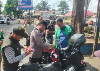 Petugas Direktorat Intelkam Polda Jambi bersama pengurus DPW Tekab Provinsi Jambi memasang bendera Merah Putih di kendaraan ojek online saat memperingati HUT ke-80 RI di kawasan Kota Baru, Jambi, Rabu (6/8/2025). (Foto: Nahar)