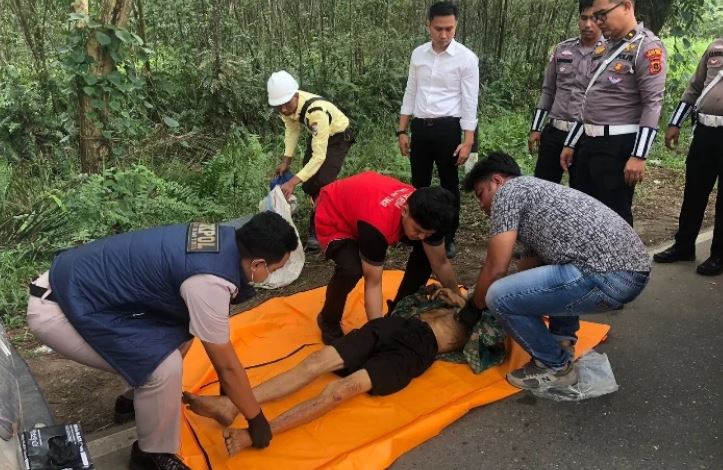 Petugas kepolisian bersama tim medis mengevakuasi jasad pria lansia tanpa identitas yang ditemukan di pinggir Jalan Lintas Jambi–Muara Sabak, Senin (11/8/2025). (Dok. Daus)