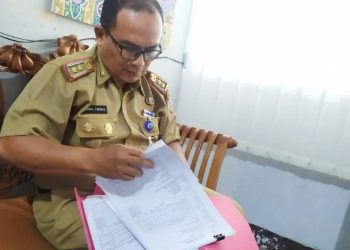 Kepala Bagian Kesra Setda Kota Jambi, Kamal Firdaus, memeriksa berkas seleksi calon pimpinan Baznas Kota Jambi periode 2025–2030 sebelum dikirim untuk verifikasi faktual di Baznas RI, Senin (11/8/2025). (Dok. Yola)
