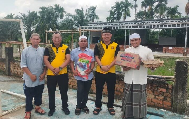 Kapolsek Jaluko IPTU Yohanes Chandra menyerahkan bantuan dalam program Jum’at Berkah di Ponpes Tahfiz Quran Sungai Duren, Jumat (1/8/2025). (Dok. Nahar)