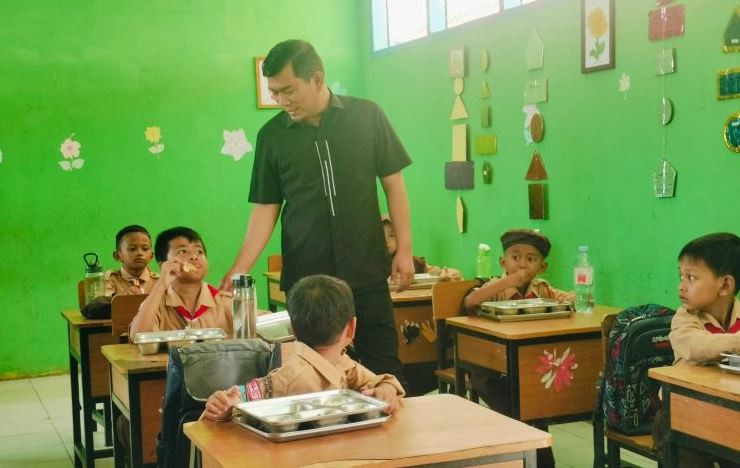 Anggota Komisi XII DPR RI, Rocky Candra, berdialog dengan siswa SDN 198/IV Telanaipura, Kota Jambi, saat meninjau pelaksanaan Program Makan Bergizi Gratis, Kamis (14/8/2025). (dok. stepanus)