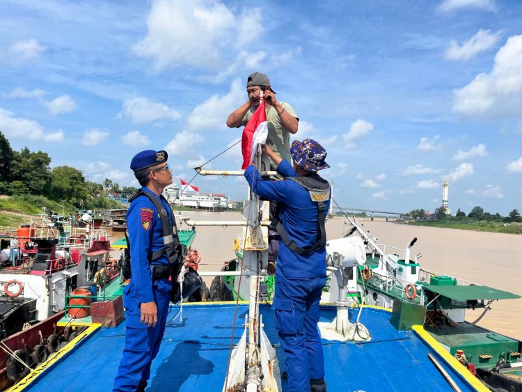 Personel Ditpolairud Polda Jambi membantu memasang bendera merah putih di salah satu kapal warga di Sungai Batanghari, Rabu (6/8/2025), (dok.humas)