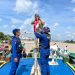 Personel Ditpolairud Polda Jambi membantu memasang bendera merah putih di salah satu kapal warga di Sungai Batanghari, Rabu (6/8/2025), (dok.humas)
