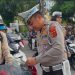 Kasat Lantas Polresta Jambi AKP Hadi Siswanto memasang bendera merah putih di kendaraan salah satu pengendara di Simpang Jelutung, Jambi, Rabu (6/8/2025).(Dok.Stepanus)