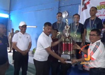Bupati Kerinci Monadi menyerahkan piala bergilir kepada tim Forum Kepala Puskesmas yang menjuarai Turnamen Bulutangkis Bupati Cup 2, Jumat (8/8/2025).(Dok.Yola)