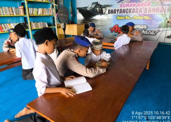 Personel Ditpolairud Polda Jambi memberikan motivasi gemar membaca kepada siswa SDN 30 Kuala Jambi di Rumah Baca Bhayangkara Bahari, Jumat (8/8/2025) (dok.Humas)