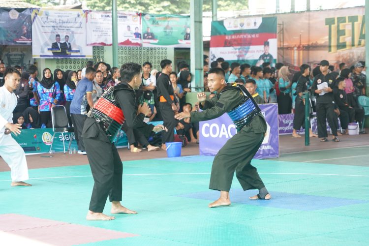 Dua pesilat saling adu strategi pada hari kedua Open Turnamen Pencak Silat Piala Danrem 042/Gapu di Lapangan Tenis Indoor Korem 042/Gapu, Jambi, Sabtu (10/8/2025). (Dok.Nahar)