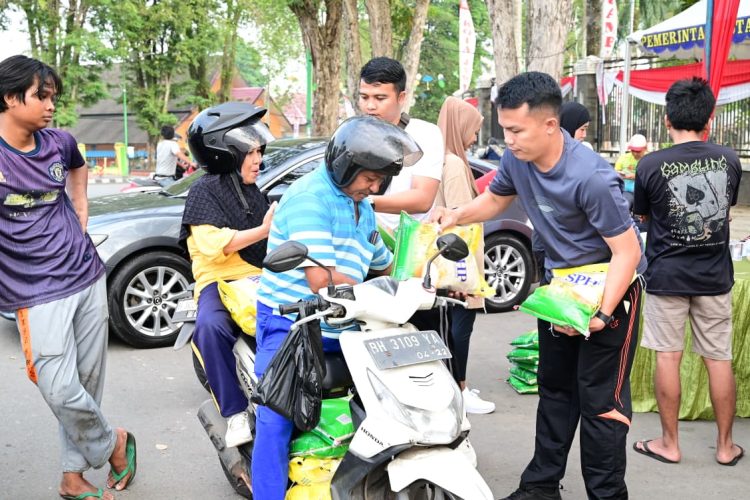 Petugas membagikan beras SPHP kepada warga dalam Gerakan Pangan Murah yang digelar Polda Jambi di kawasan Tugu Keris, Kota Jambi, Minggu (10/8/2025). (Dok.Nahar)