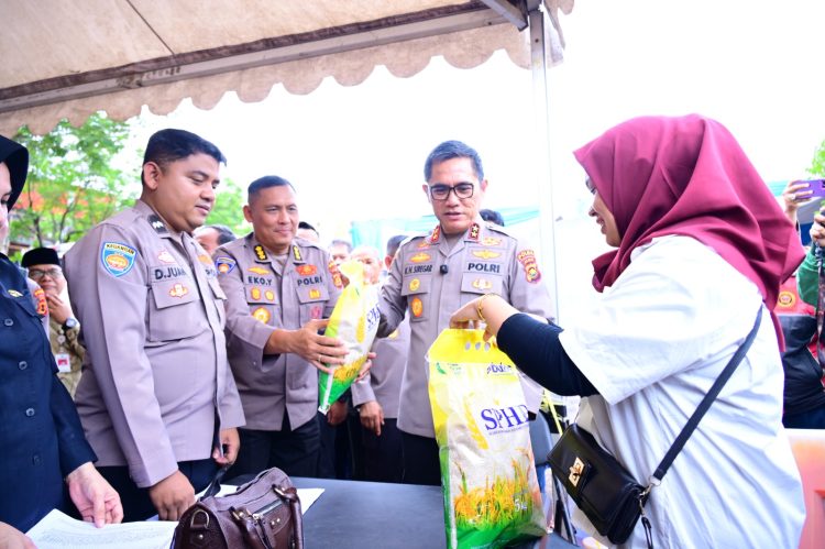 Kapolda Jambi Irjen Pol Krisno H. Siregar bersama jajaran menyerahkan beras SPHP kepada warga dalam kegiatan Gerakan Pangan Murah di GOR Kota Baru, Jambi, Kamis (14/8/2025). (Dok. Nahar)