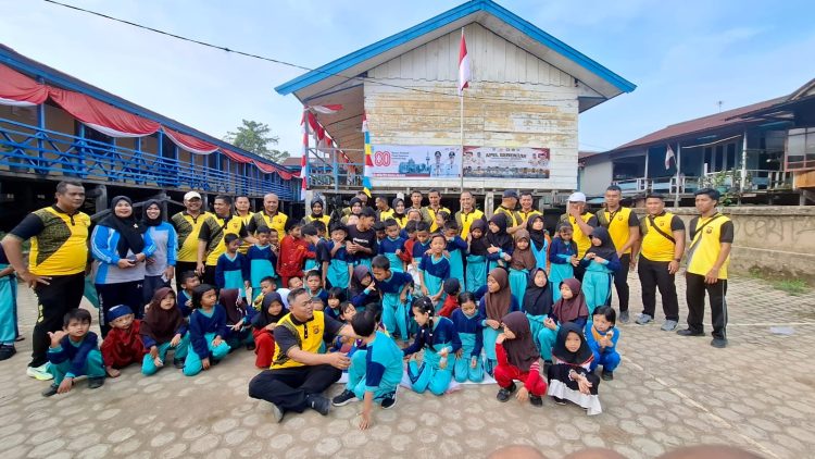 Dirpolairud Polda Jambi, Kombes Pol Agus Tri Waluyo, bersama personel berfoto bersama siswa SDN 143 Pulau Pandan usai mengikuti lomba HUT ke-80 RI, Jumat (15/8/2025).(Dok.Nahar)