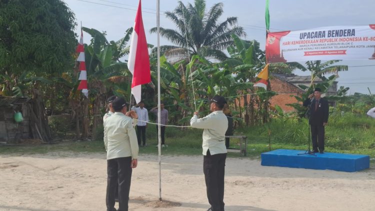 Petugas mengibarkan bendera Merah Putih pada upacara peringatan HUT ke-80 RI di Perumnas Aurduri Blok C, Kelurahan Aurkenali, Kecamatan Telanaipura, Kota Jambi, Minggu (17/8/2025). (Dok.Stepanus)