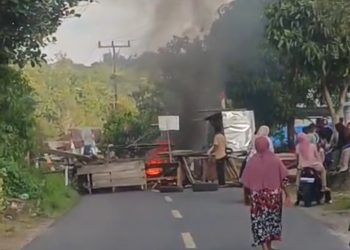 Warga memblokir jalan nasional Kerinci–Bangko di Desa Pulau Pandan, Kabupaten Kerinci, dengan membakar ban dan memasang barikade kayu, Jumat (22/8/2025). (Dok. Warga)