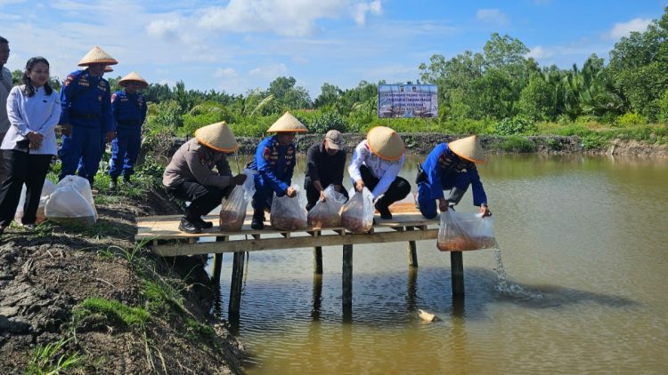 Ditpolairud Polda Jambi, Kombes Pol Agus Tri Waluyo bersama unsur TNI, pemerintah daerah, dan masyarakat saat menebar 5.000 bibit ikan nila di kolam milik warga di Parit 8, Desa Tungkal I, Kabupaten Tanjung Jabung Barat, Rabu (6/8/2025). (Dok.Humas)