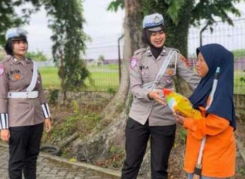 Anggota Satlantas Polresta Jambi menyerahkan bantuan sembako kepada petugas kebersihan dalam kegiatan Jumat Berkah di kawasan Thehok, Kota Jambi, Jumat (22/8/2025).(dok. Nahar)