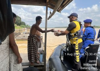 Personel Ditpolairud Polda Jambi menyerahkan bantuan makanan kepada warga pesisir Sungai Batanghari, Jumat (1/8/2025). (Dok. Humas)