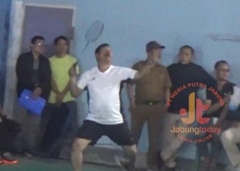 Bupati Kerinci, Monadi, melakukan smash dalam laga ekshibisi pembuka Turnamen Bulutangkis Bupati Cup II 2025 di Gedung Serbaguna Desa Dusun Baru, Kecamatan Siulak, Selasa (5/8). (Dok. Yola)