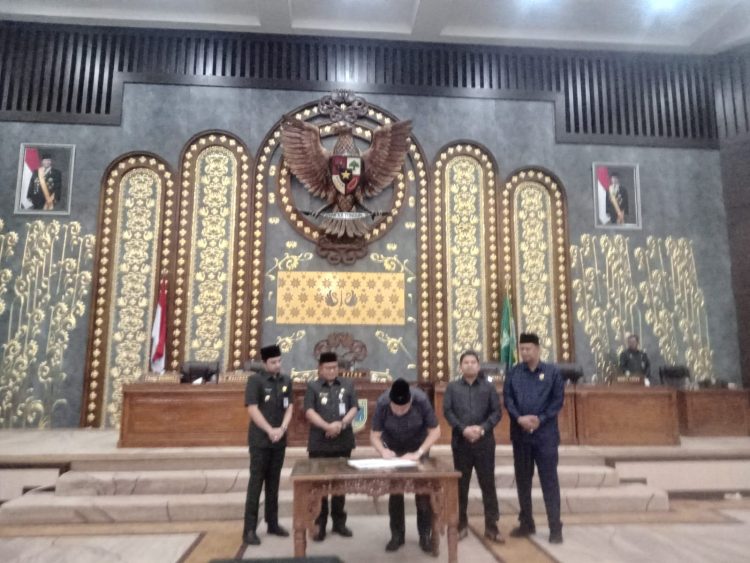 Ketua DPRD Kota Jambi, Kemas Faried Alfarelly, bersama Wali Kota Jambi, Dr. dr. H. Maulana, MKM, menandatangani pengesahan tiga Ranperda prioritas dalam rapat paripurna di Gedung Swarna Bhumi, Senin (11/8/2025). (Dok. Yola)