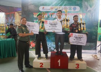 Danrem 042/Gapu Brigjen TNI Heri Purwanto (kiri) menyerahkan hadiah kepada juara umum Pencak Silat Kelas Prestasi pada penutupan Open Turnamen Piala Danrem 042/Gapu HUT ke-80 RI di Lapangan Tenis Indoor Korem 042/Gapu, Jambi, Rabu (13/8/2025). (Dok,. Nahar)