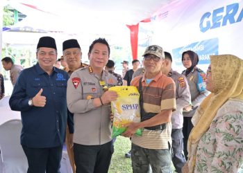 Kapolresta Jambi Kombes Pol Boy Sutan Binanga Siregar menyerahkan beras SPHP secara simbolis kepada warga dalam kegiatan Gerakan Pangan Murah di Lapangan Utama Grha Siginjai, Kantor Wali Kota Jambi, Kamis (14/8/2025). (Dok . Nahar)