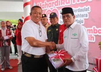 Danrem 042/Gapu Brigjen TNI Heri Purwanto, S.E., M.Sc. menyerahkan bendera Merah Putih kepada perwakilan peserta pada Gebyar Mahardika HUT ke-80 RI di Jambi, Sabtu (16/8/2025). (Dok. Nahar)