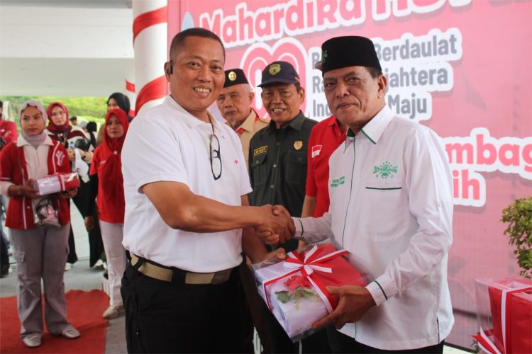 Danrem 042/Gapu Brigjen TNI Heri Purwanto, S.E., M.Sc. menyerahkan bendera Merah Putih kepada perwakilan peserta pada Gebyar Mahardika HUT ke-80 RI di Jambi, Sabtu (16/8/2025). (Dok. Nahar)
