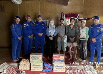 Personel Ditpolairud Polda Jambi bersama aparat desa menyerahkan bantuan sembako kepada warga korban tanah longsor di Desa Mendahara Tengah, Kecamatan Mendahara, Kabupaten Tanjung Jabung Timur, Sabtu (9/8/2025). (Dok.Daus)