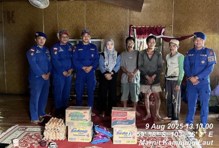 Personel Ditpolairud Polda Jambi bersama aparat desa menyerahkan bantuan sembako kepada warga korban tanah longsor di Desa Mendahara Tengah, Kecamatan Mendahara, Kabupaten Tanjung Jabung Timur, Sabtu (9/8/2025). (Dok.Daus)