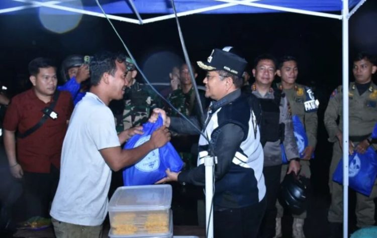 Wali Kota Jambi Maulana berbincang dengan pedagang sambil menyerahkan bantuan sembako saat patroli malam, Selasa (2/9/2025). (Dok. Daus)