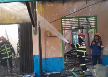 Petugas pemadam kebakaran berupaya memadamkan api yang melahap SMP Negeri 20 Kota Jambi di Jalan Dharmapala, Rabu (10/9/2024) pagi. (Dok. Daus)