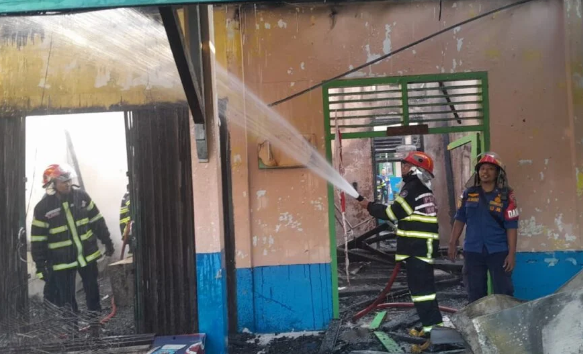 Petugas pemadam kebakaran berupaya memadamkan api yang melahap SMP Negeri 20 Kota Jambi di Jalan Dharmapala, Rabu (10/9/2024) pagi. (Dok. Daus)