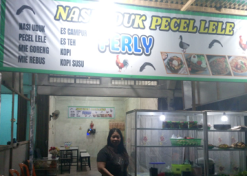 Pemilik warung, Yuli, berdiri di depan “Nasi Uduk Pecel Lele FERLY” di Desa Tangkit, Muaro Jambi. (Dok .Daus)
