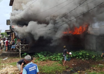 Asap tebal membumbung saat kebakaran melanda rumah warga di Lorong Diamon, Nipah Panjang, Tanjung Jabung Timur, Sabtu (13/9/2025). Warga bersama aparat berupaya memadamkan api. (Dok. Warga)