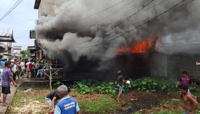 Asap tebal membumbung saat kebakaran melanda rumah warga di Lorong Diamon, Nipah Panjang, Tanjung Jabung Timur, Sabtu (13/9/2025). Warga bersama aparat berupaya memadamkan api. (Dok. Warga)