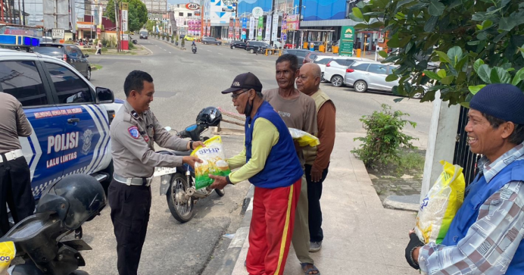 Anggota Satlantas Polda Jambi membagikan bantuan beras kepada warga dalam kegiatan bakti sosial memperingati Hari Lalu Lintas Bhayangkara ke-70, Selasa (16/9/2026). (Dok. Nahar)