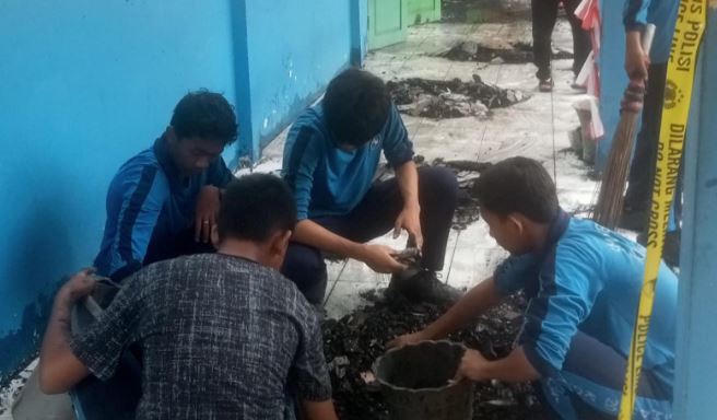Siswa SMP Negeri 20 Kota Jambi membersihkan puing sisa kebakaran di area sekolah, Kamis (11/9/2025), sebagai bentuk kepedulian dan gotong royong. (Dok. Daus)