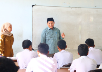 Ketua Divisi Hukum dan Pengawasan KPU Provinsi Jambi, Suparmin (kanan), memberikan pembekalan kepemiluan kepada siswa SMAN 12 Kota Jambi dalam program KPU Goes to School, Senin (22/9/2025). (Dok. Daus)
