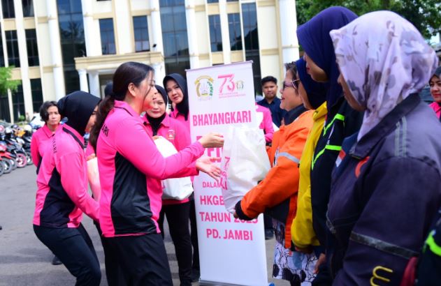 Ketua Bhayangkari Daerah Jambi, Ny. Evi Krisno, menyerahkan paket sembako kepada pengemudi ojek online perempuan dalam kegiatan bakti sosial memperingati Hari Kesatuan Gerak Bhayangkari (HKGB) ke-73 di Kota Jambi. (Dok, Nahar)